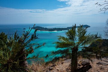 Behold this breathtaking tropical island vista: turquoise waters, lush greenery, and a panoramic view from above!