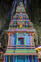 A vibrant Hindu shrine stands majestically inside a cave, its colorful details adding to its sacred aura.