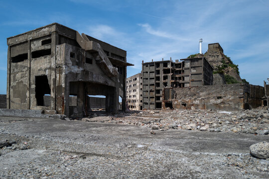 Ghostly ruins of Hashima Island under a clear blue sky; a poignant reminder of its past.