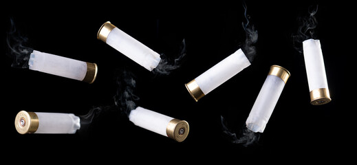 White shotgun shell with smoke flying through the air on black