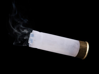 White shotgun shell with smoke flying through the air on black