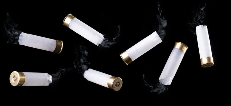 White shotgun shell with smoke flying through the air on black