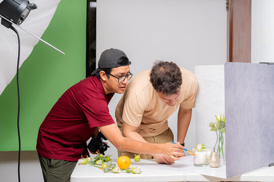 Photographers preparing scented candles for product photography session
