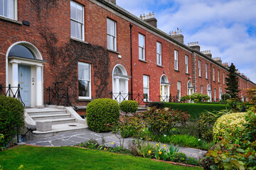 Row of brick townhouses with front gardens
