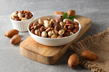 Assorted nuts in white bowls on a gray background