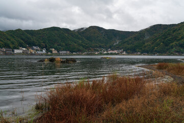 Obraz premium Lake Kawaguchi (Kawaguchi-ko, Estuary Lake) near Mount Fuji and frozen lava in the foreground on a cloudy autumn day, Fujikawaguchiko, Yamanashi Prefecture, Japan