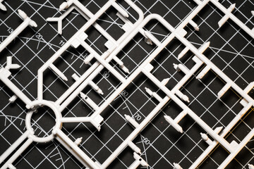 White plastic model kit runner frame on black cutting mat. Remaining plastic runner frame after cutting model kit parts. Wallpapers Backgrounds. Abstract Texture. White and black colours