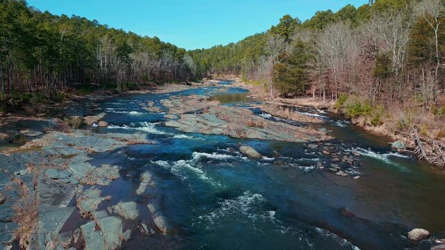 Low aerial flyover of Mountain Fork River rapids inside Beavers Bend State Park, Oklahoma.