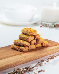 Indonesian castangel snack. Cookies are perfectly arranged on a wooden board with a glass of milk nearby, creating a cozy snack setting perfect for any time of day