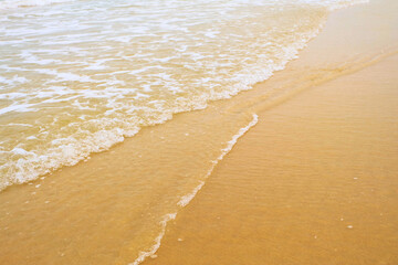 Sandy beach and sea waves in summer.