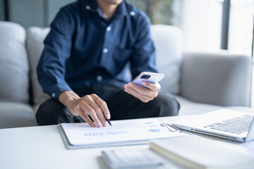 Man calculate finances home pay bills taxes on mobile phone and calculator financial at home