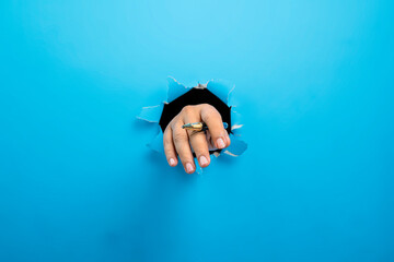 Human hand holding ballpoint pen through ripped paper. Mockup or Copy space. Concept of business,...