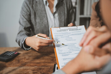 Businesswoman pointing at contract agreement with pen during business meeting