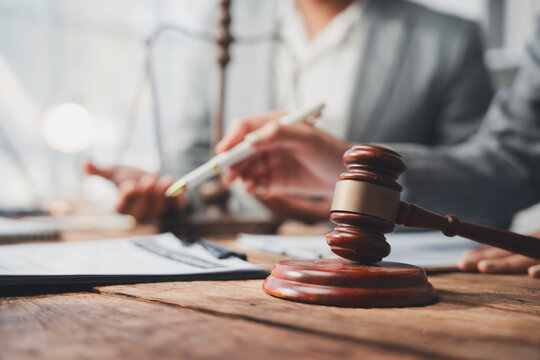 Lawyers discussing contract behind judge gavel in courtroom