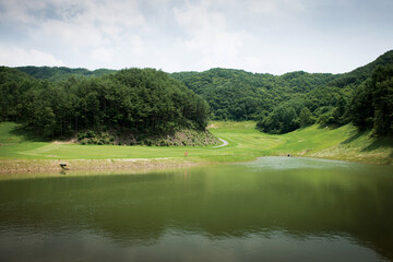 자연의 산과 숲이 어울어진 녹색의 골프장.