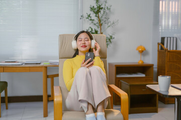 Young woman listening to music with headphones and smartphone, enjoying her leisure time at home