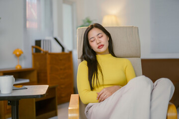 Obraz premium Young woman relaxing on armchair at home
