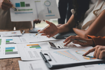 Business team analyzing financial data and using calculator during a meeting