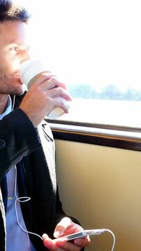 Businessman listening to music while having coffee