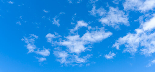 Low angle view and full frame of beautiful blue sky with strange shape of fluffy white clouds in the morning or evening on sunny day used as natural background texture in decorative art work