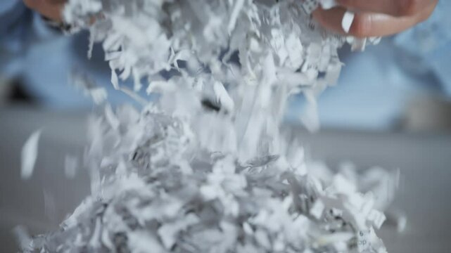 Shredded paper office documents in worker woman hands. Slow motion