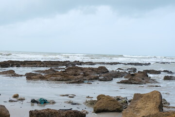 Majestic Rocky Beach with Crashing Waves and Overcast Sky in Natural Coastal Scenery