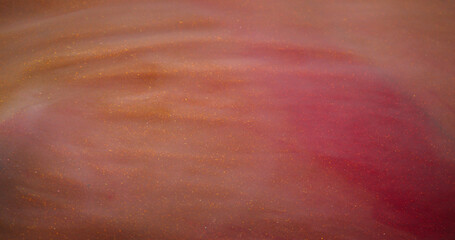 Fototapeta premium Paint flow. Shimmering fluid. Pink peach changing color stream mystic sparkling ambiance twisting marble defocused abstract background.