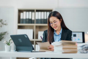 Businesswoman working at office desk taking notes on a document