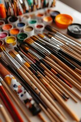 Assorted paintbrushes and paint pots arranged neatly for art