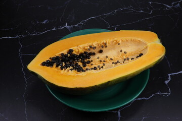 Fresh and organic ripe papaya whole vegetable on the plate. Famous tropical fruit in Asia.