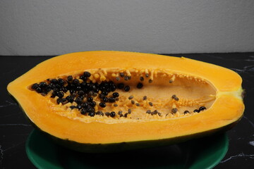 Fresh and organic ripe papaya whole vegetable on the plate. Famous tropical fruit in Asia.