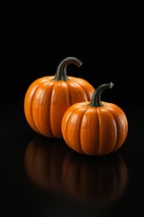 there are two small pumpkins sitting on a black surface