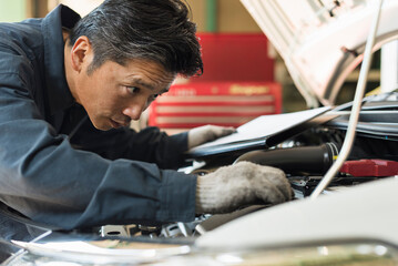自動車の点検をする40代男性整備士