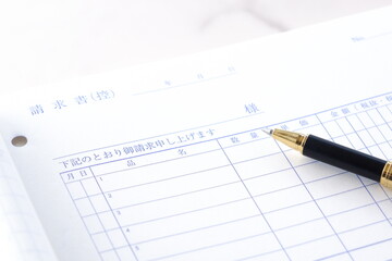 取引先に宛てた請求書を作成しているビジネスシーンのイメージ
