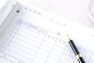 取引先に宛てた請求書を作成しているビジネスシーンのイメージ
