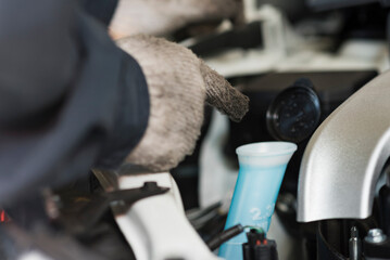自動車の点検をする40代男性整備士の手元
