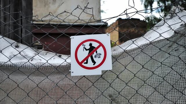Close-up of a prohibition sign on a wire fence, restricting digging or building