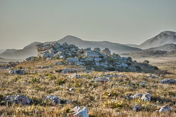  Wilderness, grass and rocks with hills landscape for travel destination, hiking adventure or discovery. Mockup space, natural terrain or field environment for sightseeing, exploration or conservation © peopleimages.com