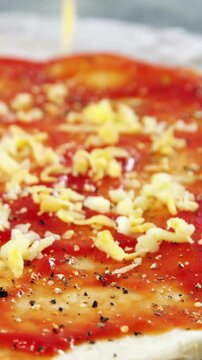 Spreading cheese toppings on pizza base
