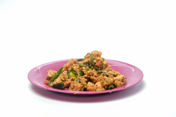 Spicy tempeh vegetables in purple plastic plate isolated on white background.Tempeh, a typical Indonesian food.Traditional food concept.Copy space for text. For graphic design or banner background