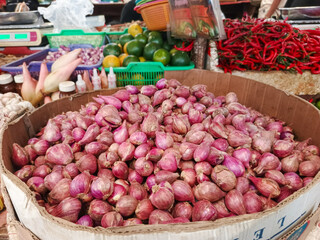 Fresh red onions or shallots piled high at market. Vibrant food ingredient, essential for cooking and flavor.