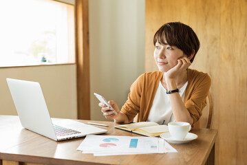 カフェで仕事をする30代女性