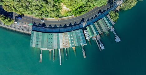Aerial view of a marina with numerous docks and boat houses. Green roofs and walkways. Tranquil water. BOAT SHEDS, ORAKEI, AUCKLAND, NEW ZEALAND