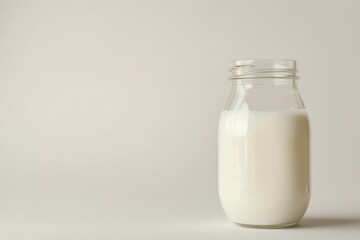 A glass bottle filled with fresh milk stands on a white background