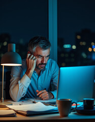a man sitting at a desk with a laptop