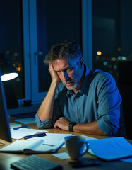a man sitting at a desk with a laptop