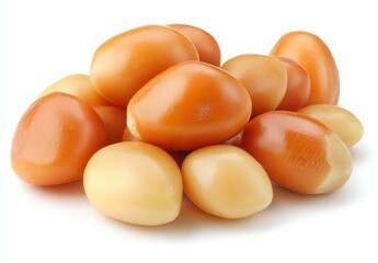 Close up of a pile of smooth, light brown and beige oval shaped seeds or nuts on a white background. The seeds have a glossy sheen and appear moist