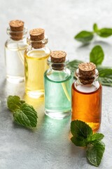 Aromatic essential oils in glass bottles with mint leaves