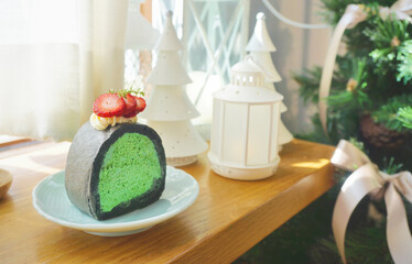 Matcha green tea mousse cake at wooden table with white decorative stuff