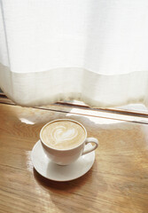 Latte coffee at table with window curtain background, Vintage color style